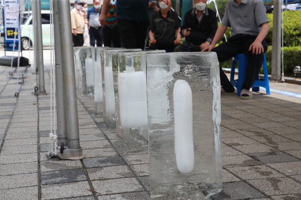 관악구 선별진료소 대기줄 사이 더운 열기를 식혀줄 얼음이 놓여있다