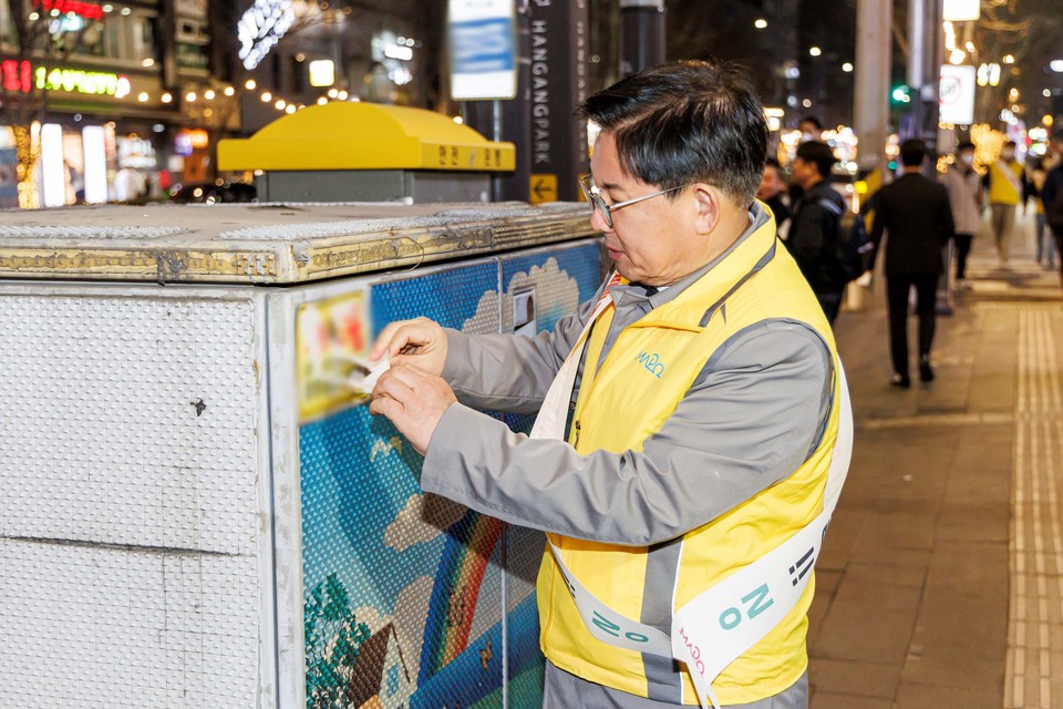 박강수 마포구청장이 지난 2월 불법광고물 단속 캠페인에 참가해 시설물에 붙은 불법광고물을 제거하고 있다.